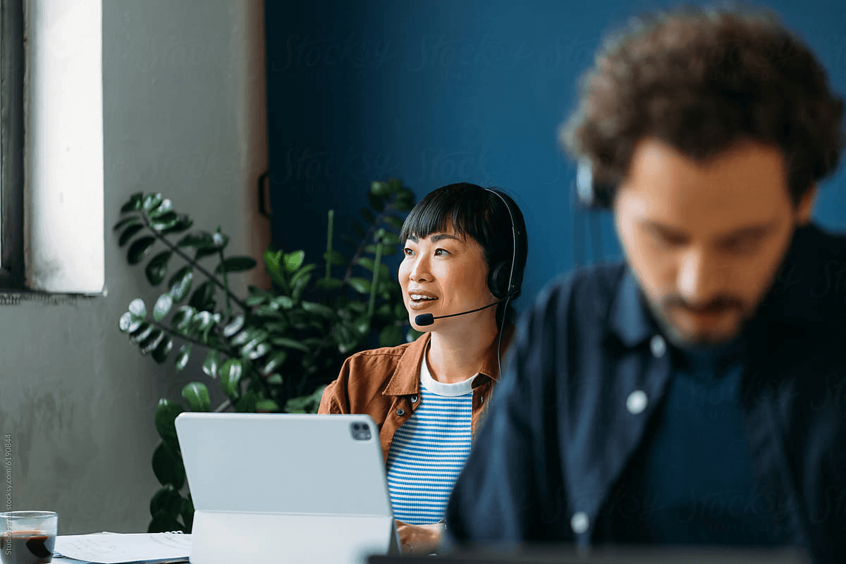 Conseillère du support Popster, casque sur les oreilles, souriante devant son écran